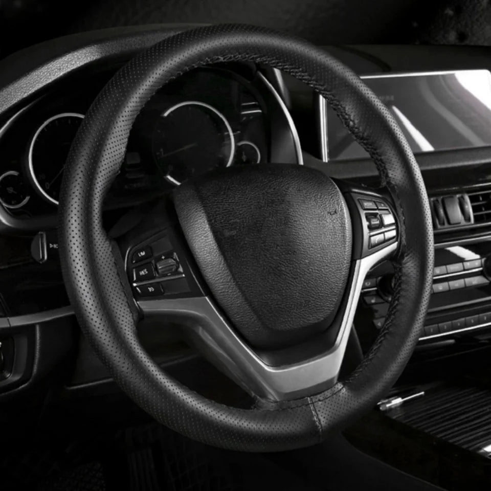 Hand-stitched black steering wheel cover installed in a car