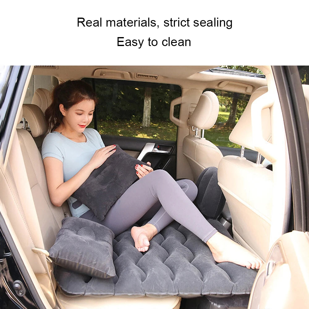 Woman resting on a black air mattress in the back seat