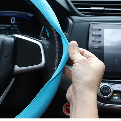 Hands holding a steering wheel with a light blue silicone cover
