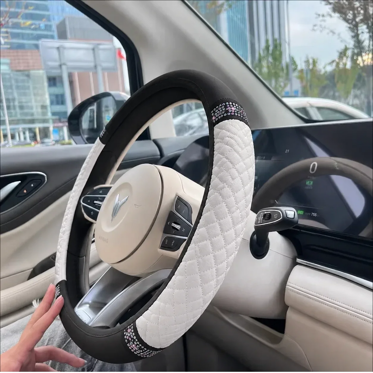 Beige perforated leather steering wheel cover held by a driver