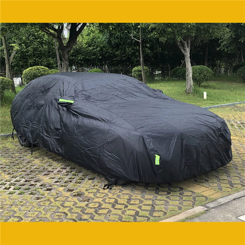 Black car cover on a car parked in a park