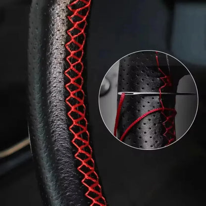 Lacing red stitching onto the steering wheel cover with a needle